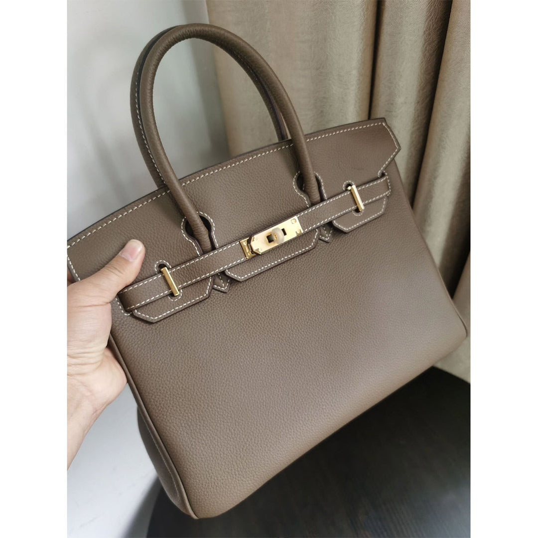 Birk-Handtasche aus Togo-Narbenleder mit Drehverschluss und Rollhenkeln