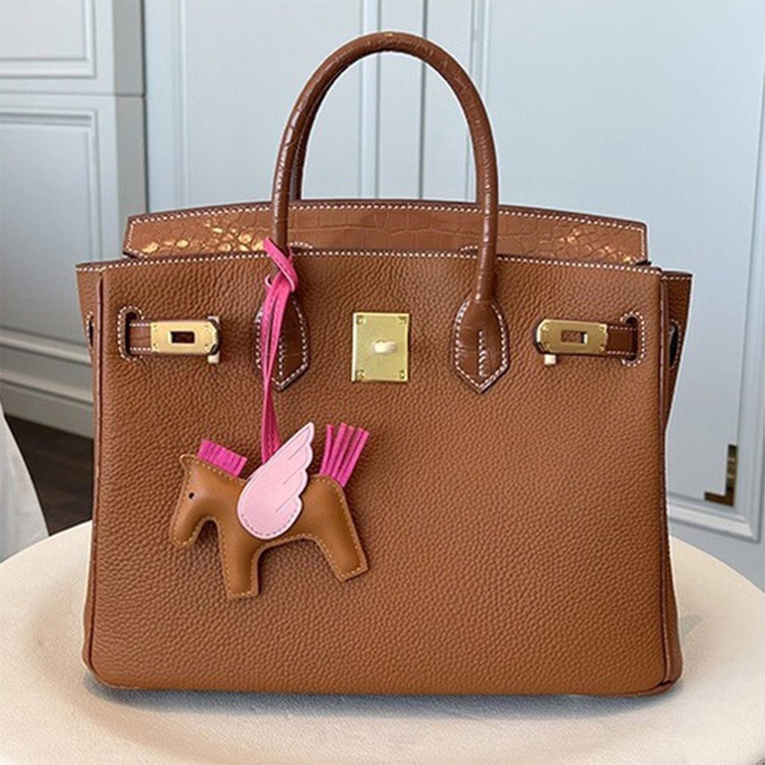 Handtasche aus Narbenleder mit Klappe in Kroko-Prägung und goldfarbenem Drehverschluss