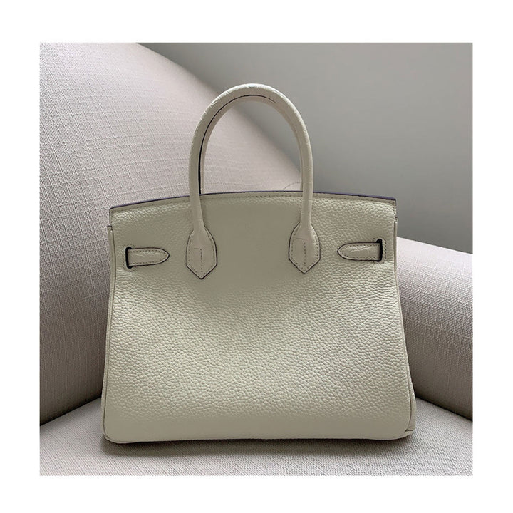 Handtasche aus Narbenleder mit Klappe in Kroko-Prägung und goldfarbenem Drehverschluss