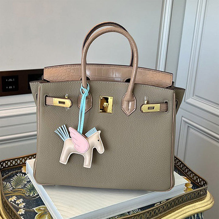 Handtasche aus Narbenleder mit Klappe in Kroko-Prägung und goldfarbenem Drehverschluss