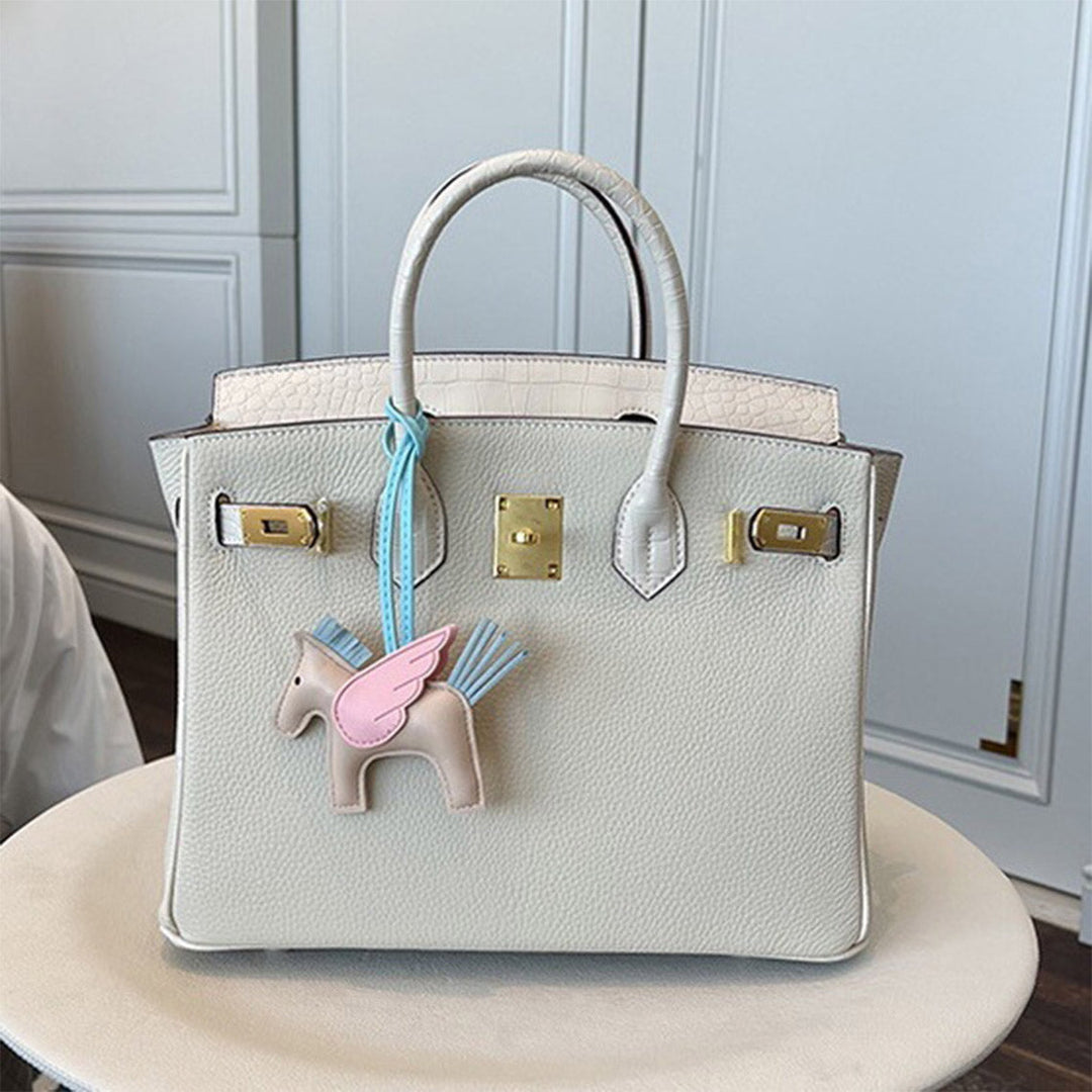 Handtasche aus Narbenleder mit Klappe in Kroko-Prägung und goldfarbenem Drehverschluss