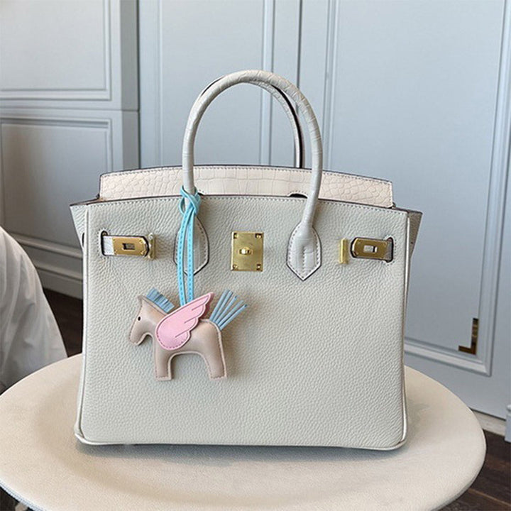 Handtasche aus Narbenleder mit Klappe in Kroko-Prägung und goldfarbenem Drehverschluss