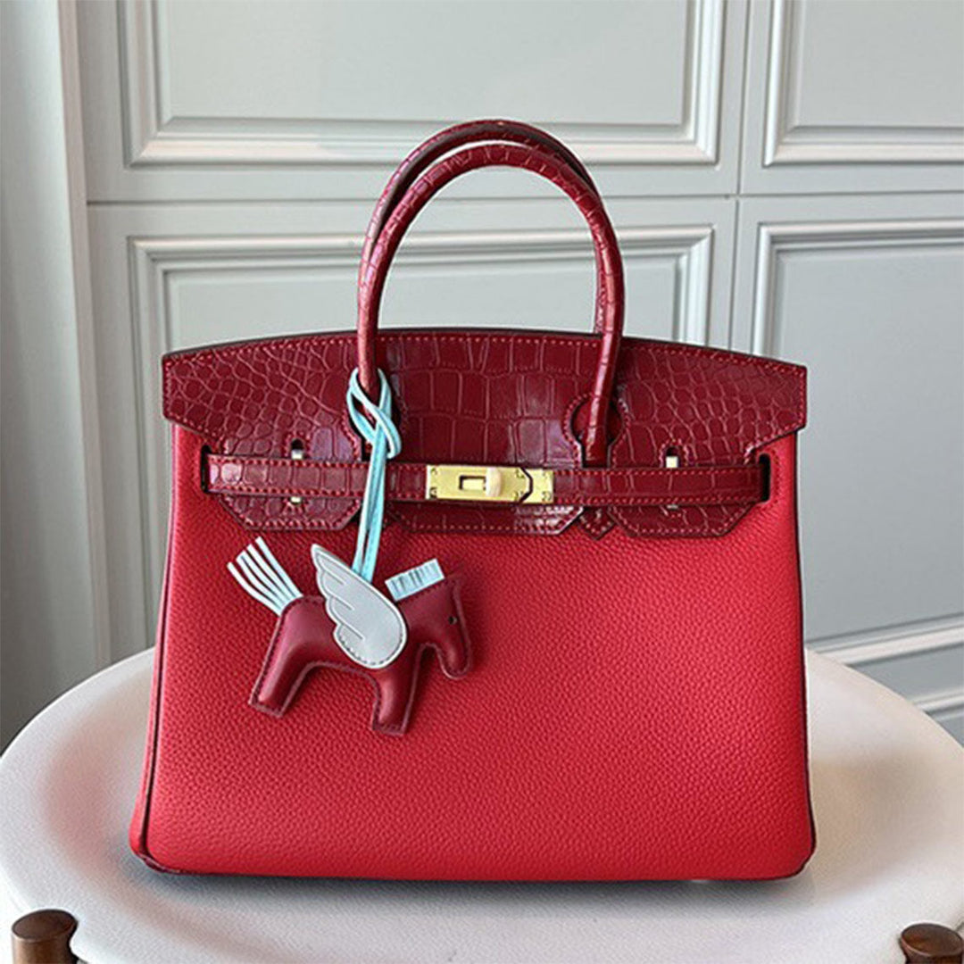 Handtasche aus Narbenleder mit Klappe in Kroko-Prägung und goldfarbenem Drehverschluss