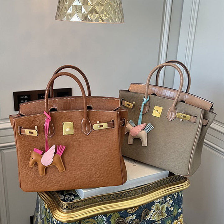 Handtasche aus Narbenleder mit Klappe in Kroko-Prägung und goldfarbenem Drehverschluss