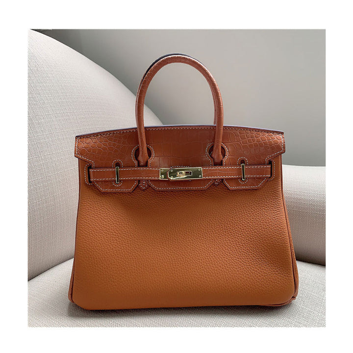 Handtasche aus Narbenleder mit Klappe in Kroko-Prägung und goldfarbenem Drehverschluss