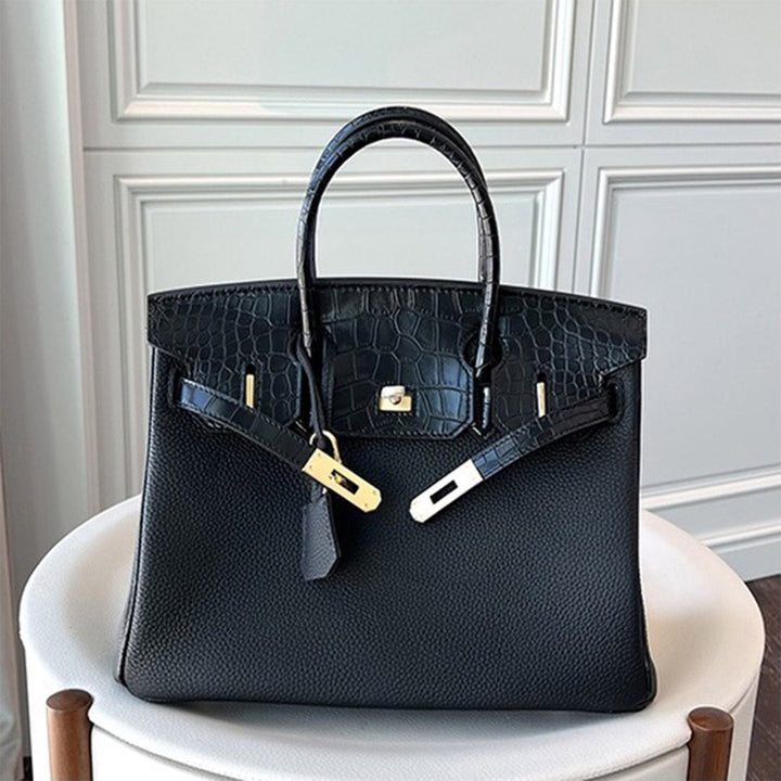 Handtasche aus Narbenleder mit Klappe in Kroko-Prägung und goldfarbenem Drehverschluss