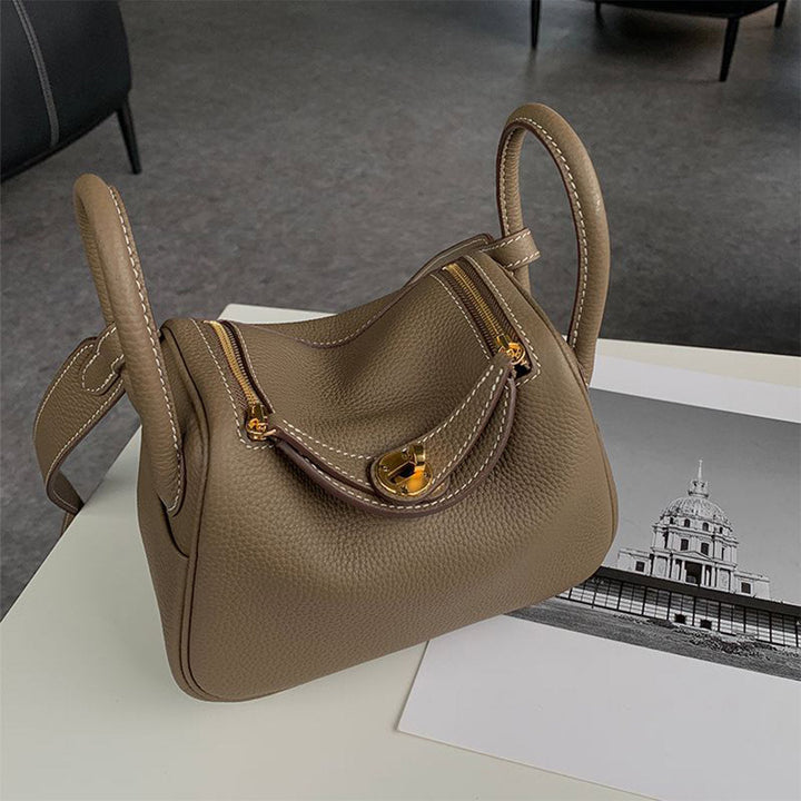 Lindi Tasche aus Narbenleder mit Henkeln und goldenen Beschlägen
